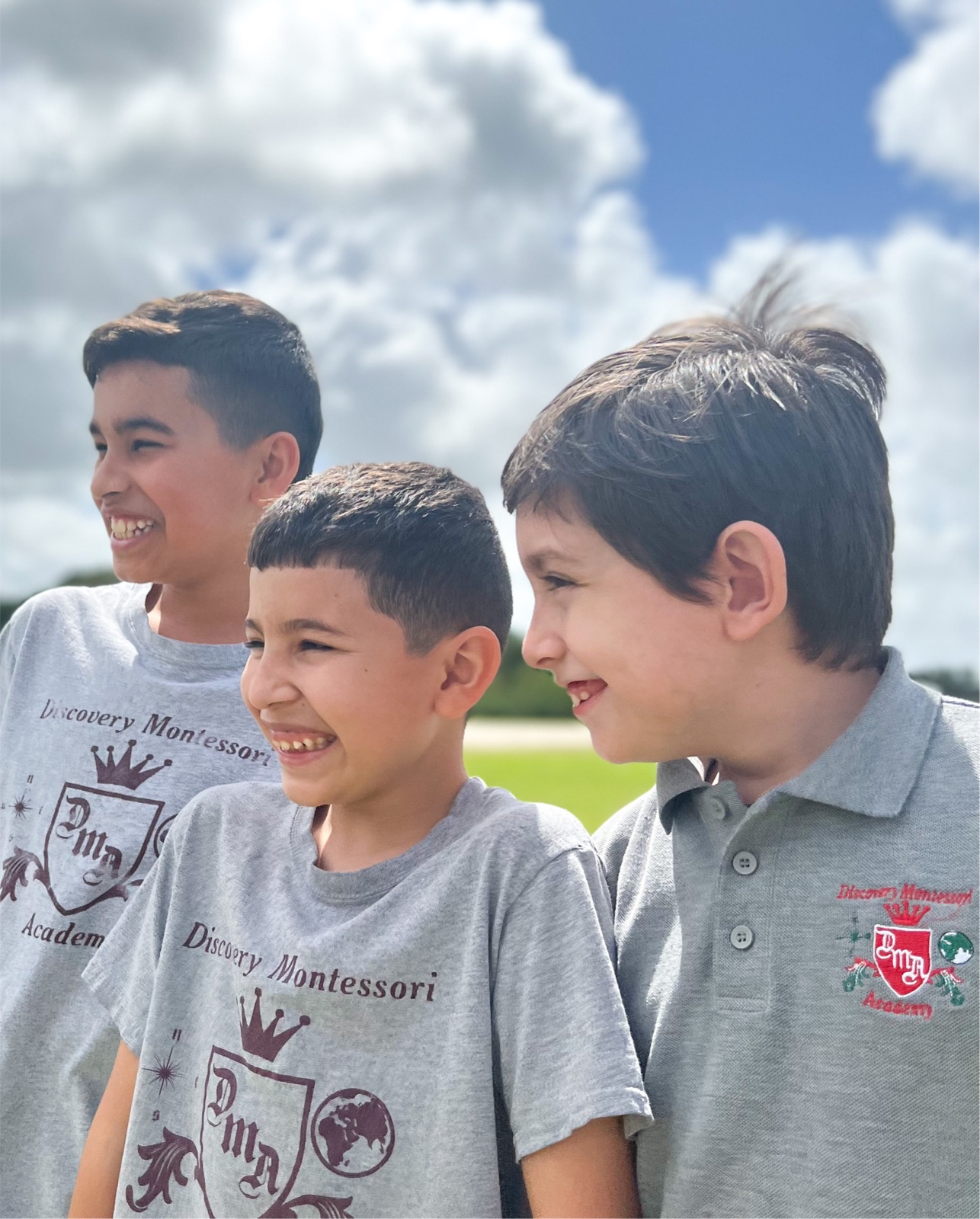 Three boys laughing on the field